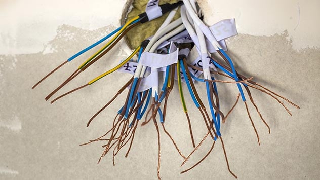 Electrical exposed connected wires protruding from socket on whi