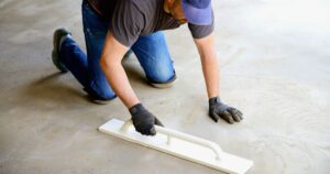 man smoothing out concrete flooring