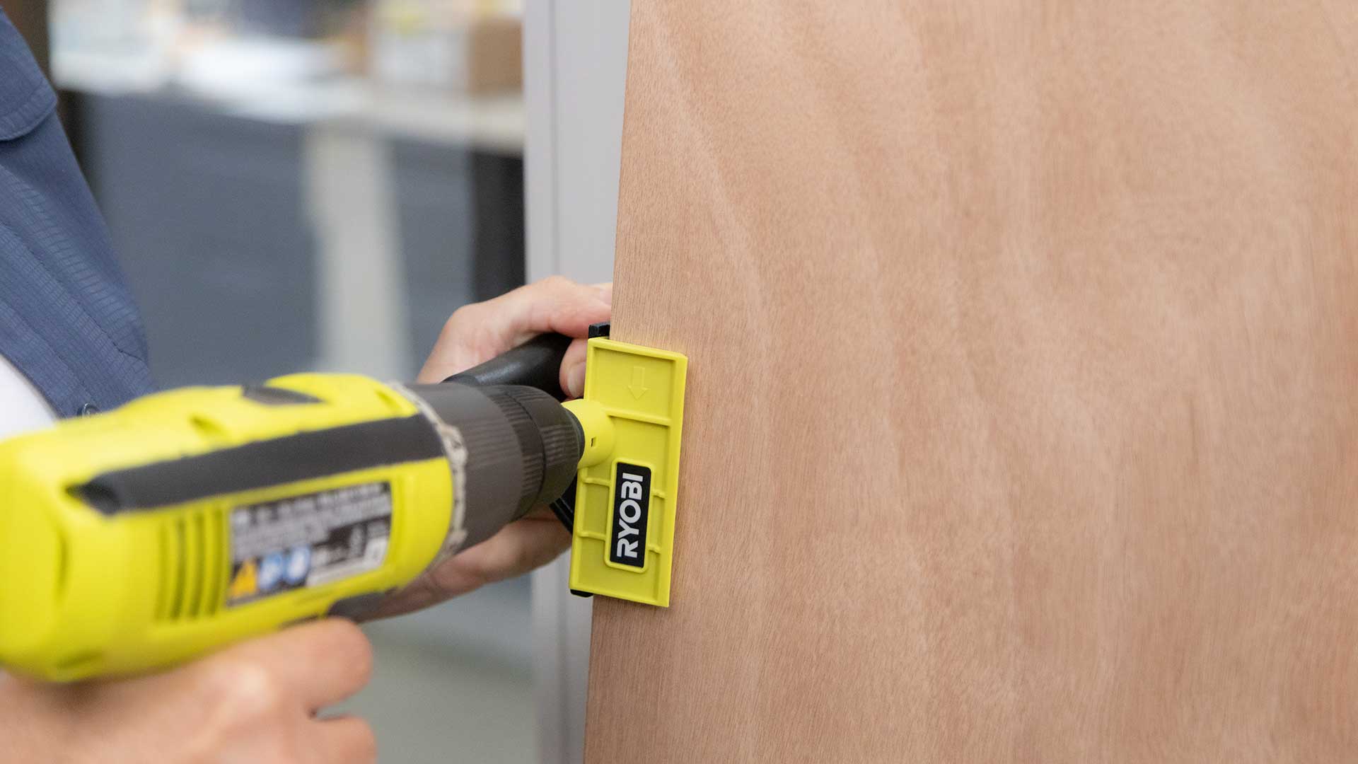 Ryobi door trimmer being demonstrated on wooden door.