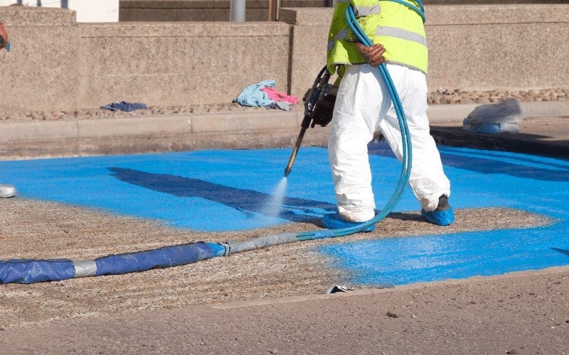 Workers spraying foam membrane onto a rooftop