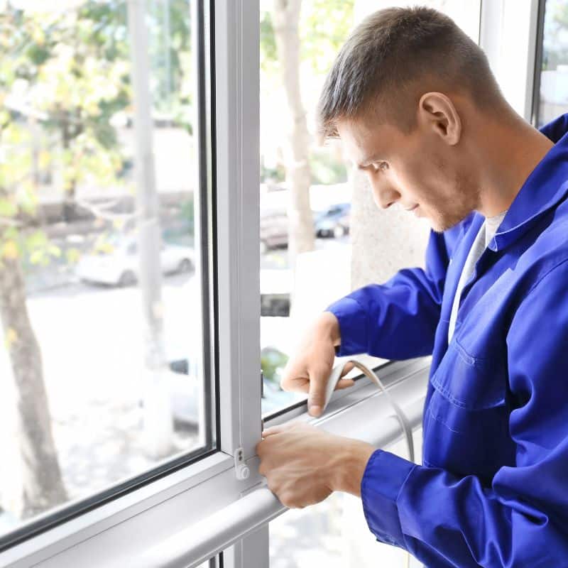 man repairing a window